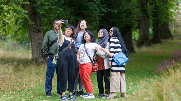A group of visitors taking a picture in the parkland